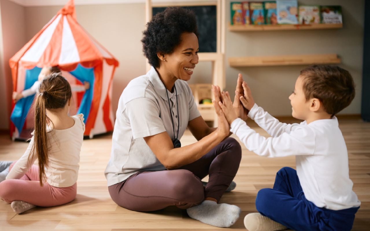 A woman and child sitting on the floor playing with each other.