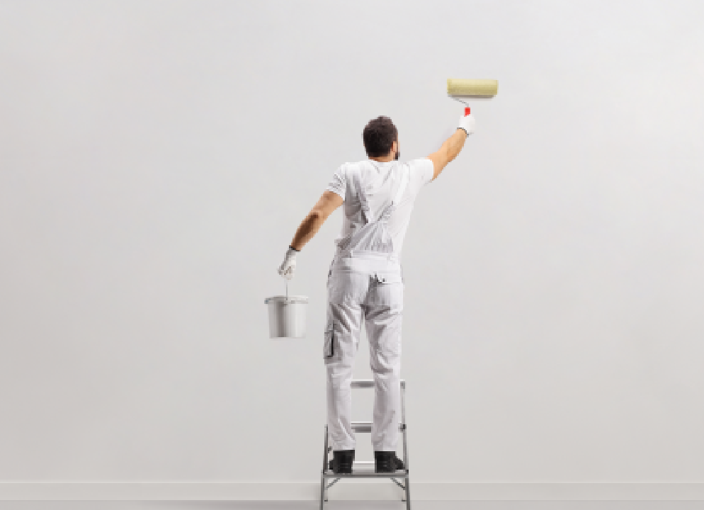 A man standing on top of a ladder painting the wall.